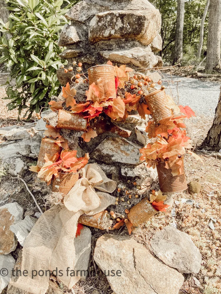 DIY Recycled Tin Can and Dollar Tree Flowers Wreath for Fall - Hanging on a rock column for Dirt Road Adventures