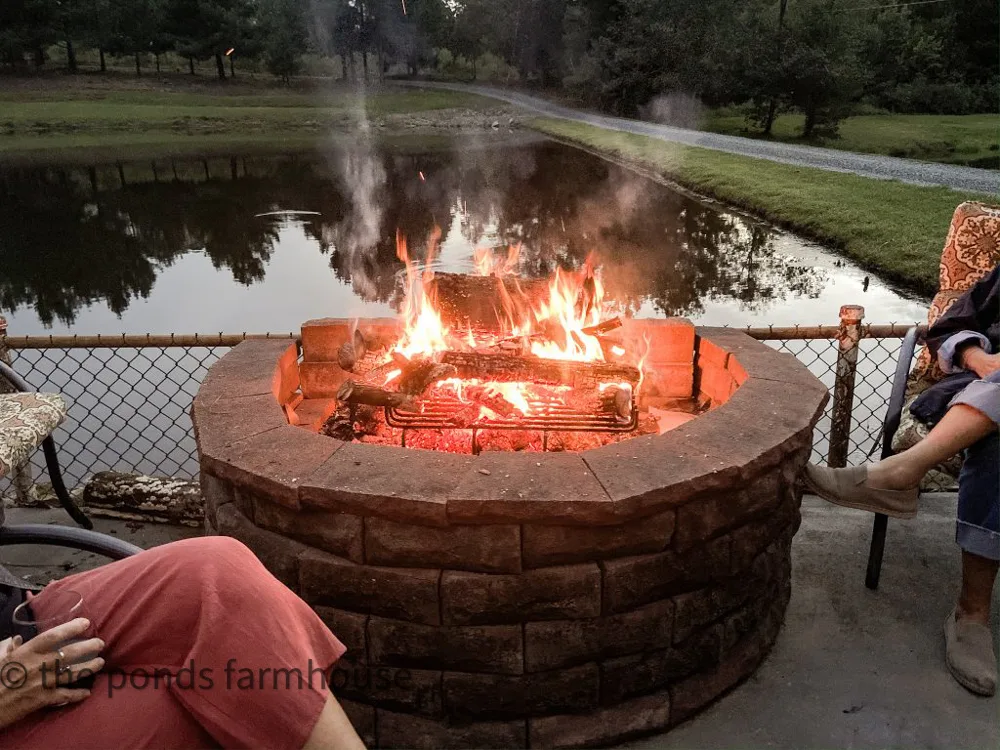 Sitting around the fire pit at dusk around the outdoor kitchen entertaining area.