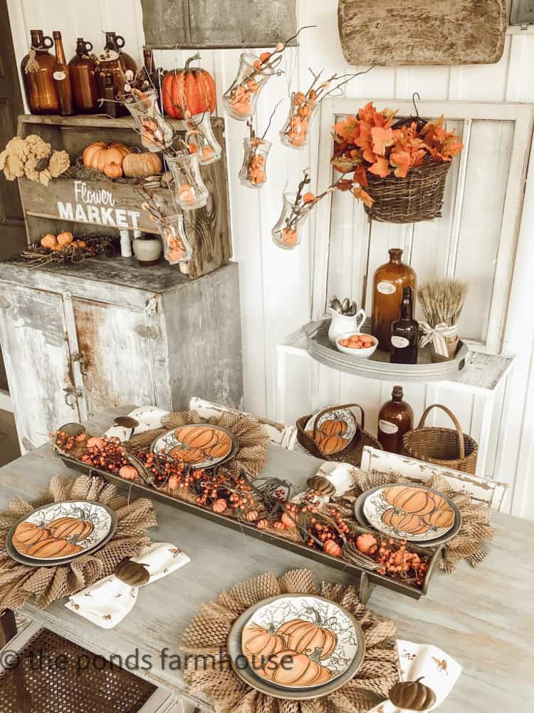 Long tray filled with bittersweet stems and mini pumpkin for fall table.