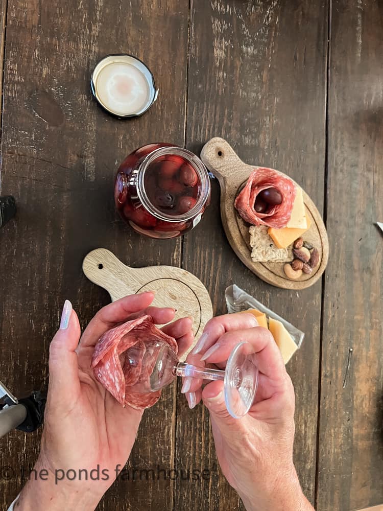 The definition of Charcuterie includes cured meats such as salami and ham.  Add a salami rosette to decorate board. 