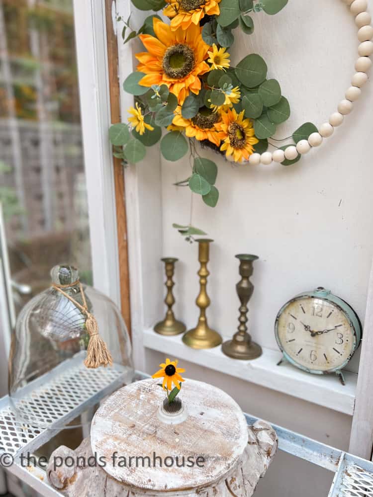 DIY Greenhouse Decorated for Late Summer with Glass Cloche, blooms and Sunflower Wreath include sunflower colors 