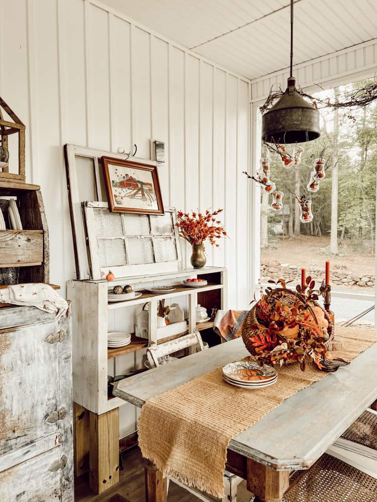 Screened porch with Ideas for Fall Basket centerpiece.  Light fixture with mini pumpkins and Stems.  