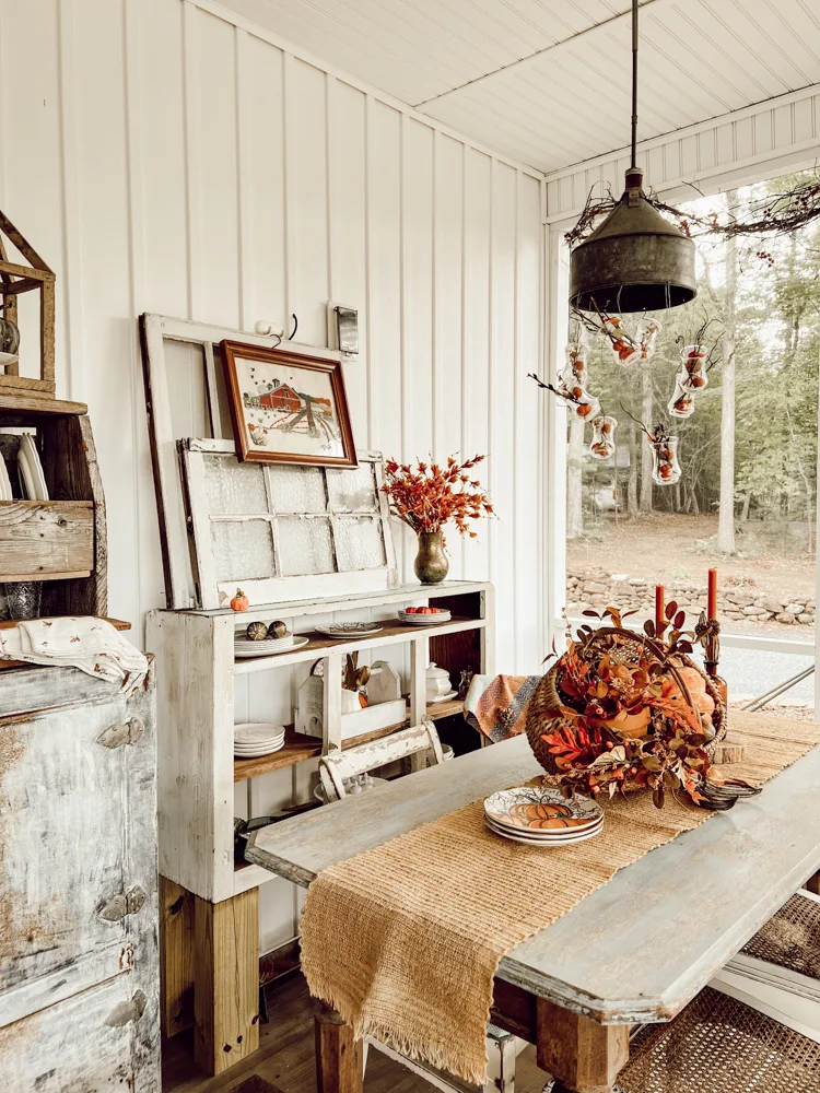 Screened porch with Ideas for Fall Basket centerpiece.  Light fixture with mini pumpkins and Stems.  