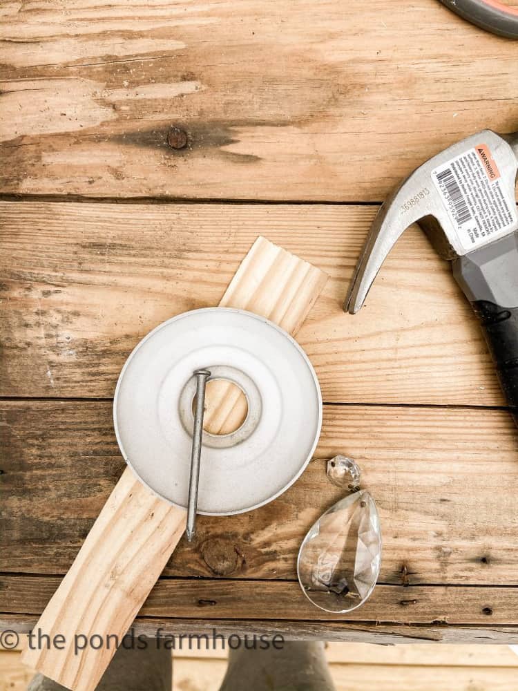 Use nail and wood block to punch holes for the vintage chandelier crystals to be added.