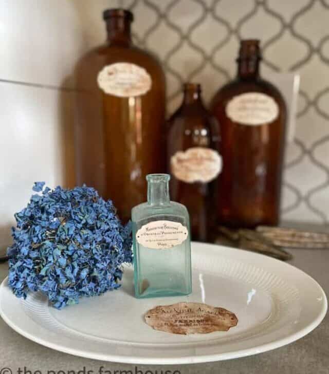 cropped-Old-Amber-Bottles-vintage-blue-medicine-bottle-on-ironstone-plate-with-dried-hydrangea-blossom-Vintage-Labels.jpg