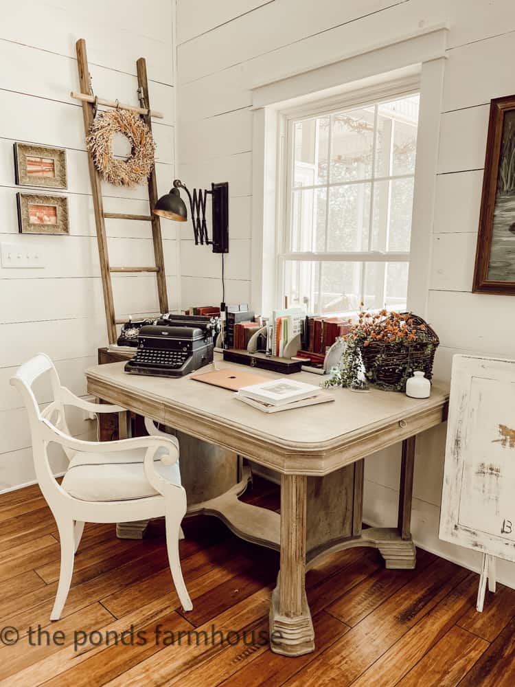 Desk with vintage typewriter and rotary telephone on repurposed dining table.