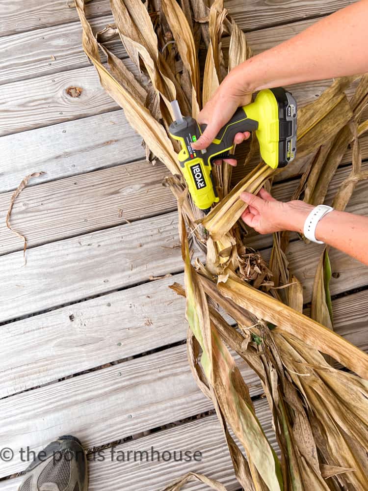 Use hot glue to finish the assembly of the farmhouse and cottage style fall garland.  