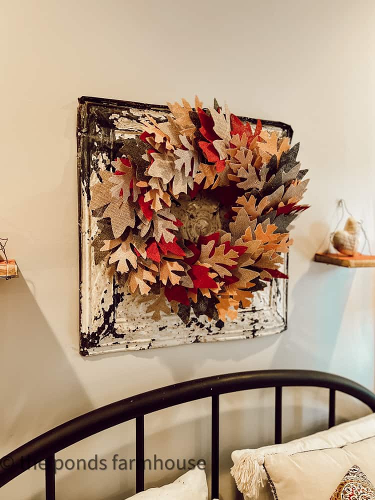 Dollar Tree Leaf Fall Wreath hanging over vintage ceiling tin in bedroom.