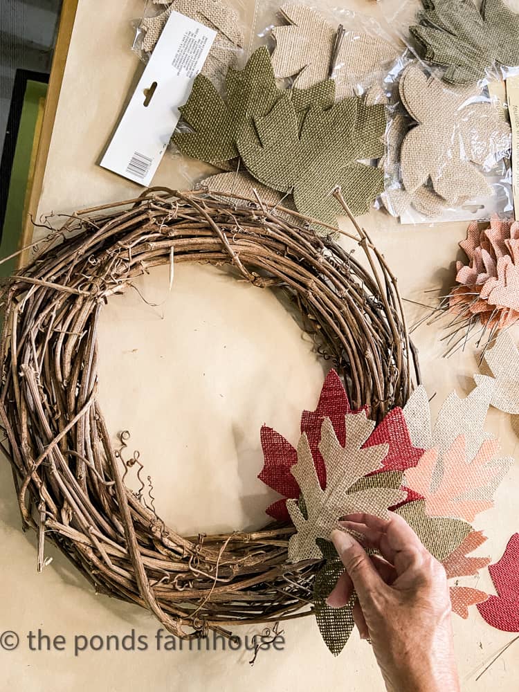 Add leaves to grapevine wreath to create a fall leaf wreath.