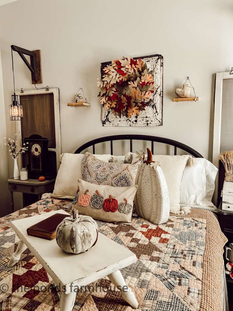 Dollar Tree DIY Leaf Wreath hangs over guest bedroom bed and matches the yard sale quilt.  