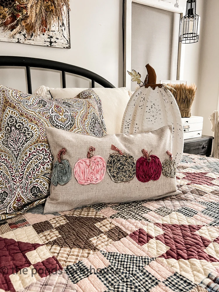 Top 10 Best Crafts of 2022 for Fall is a DIY Scrap Fabric Pumpkin Pillow Cover to match the yard sale quilt.