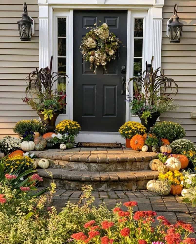 Front Stoop decorated for Fall with Tall planters and fall wreath.  Pumpkins and mums