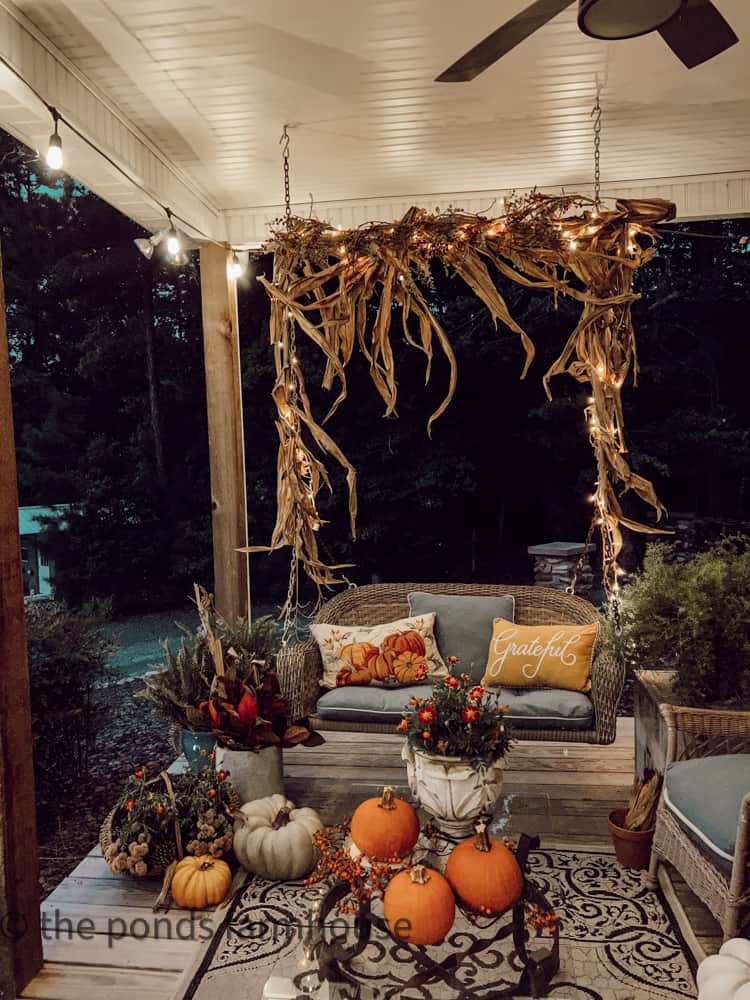 Evening view of front porch swing decorated for fall