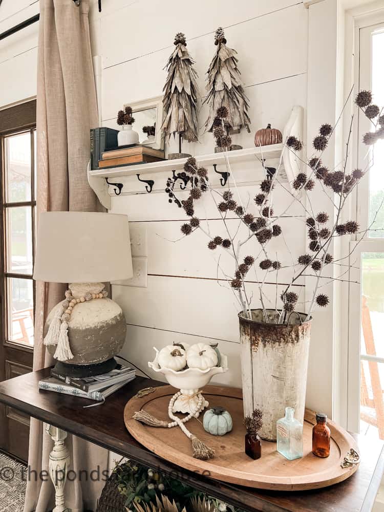 Entryway decorated for fall with DIY Corn Stalks Topiaries and Sweet Gum Ball Stems and Pumpkins.  Farmhouse Style Decorating.