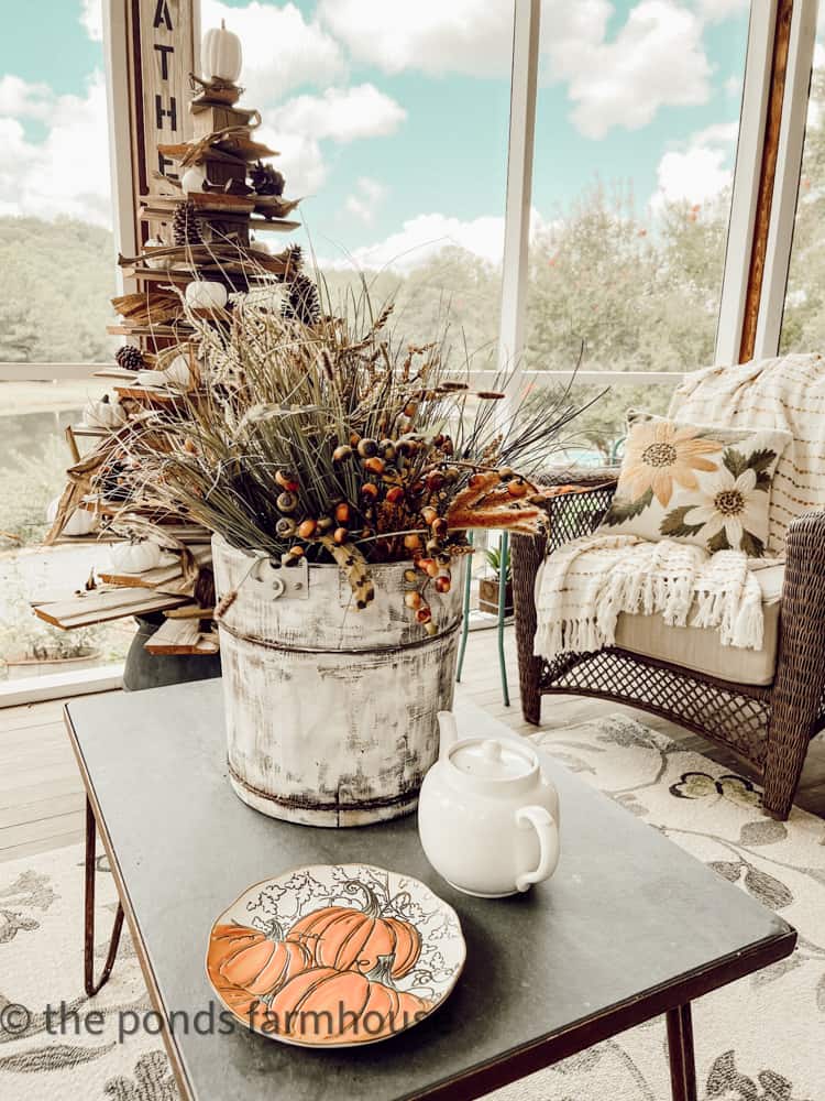 Screened-in porch decorating with roadside finds and faux stems on iron and slate coffee table.  