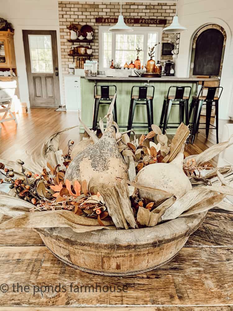 Vintage Wooden Bowl filled with corn stalks, dried gourdes and okra pods, faux fall stems and berries for fall centerpiece.  