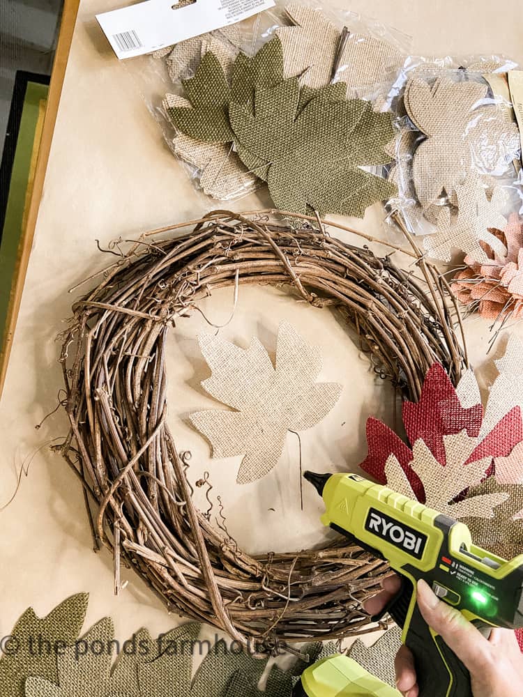 Hot Glue added to the Dollar Tree Leaf will secure it to the grapevine wreath.