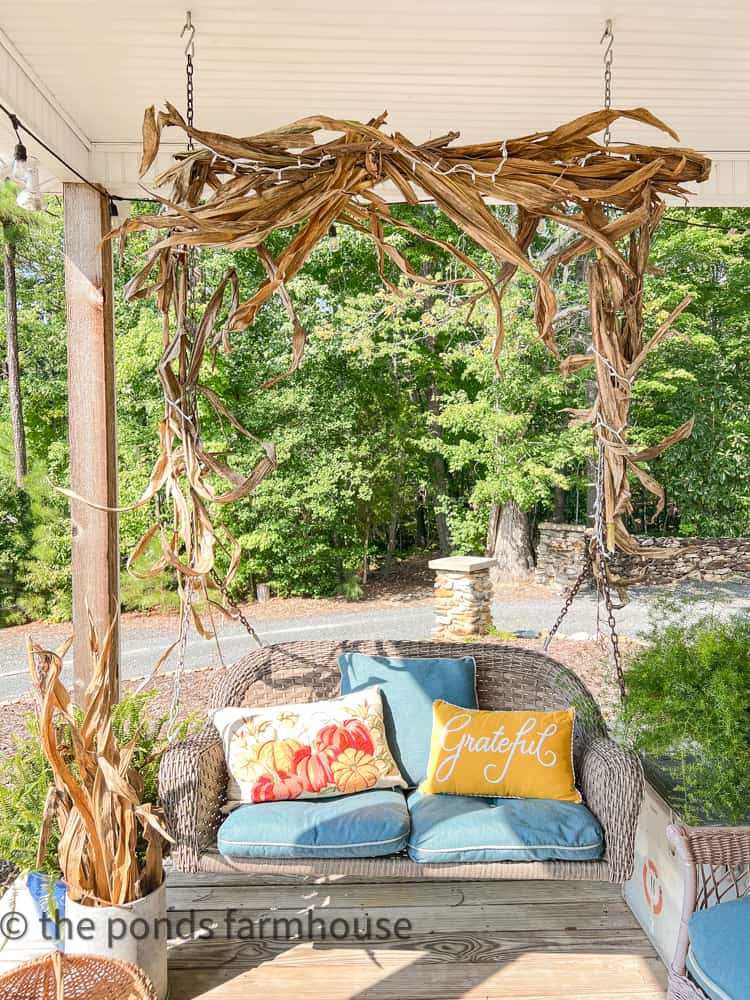 DIY Corn Stalk Garland on porch swing. 