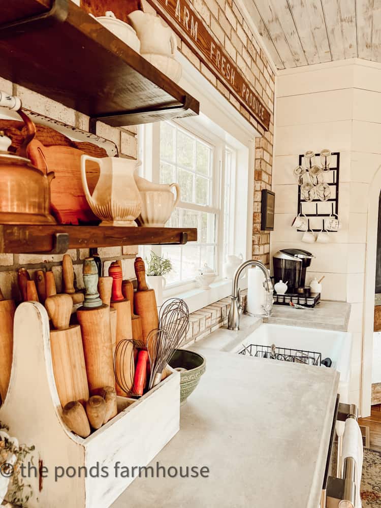 Concrete Countertops and brick wall surround the apron front farmhouse sink in modern farmhouse tour.