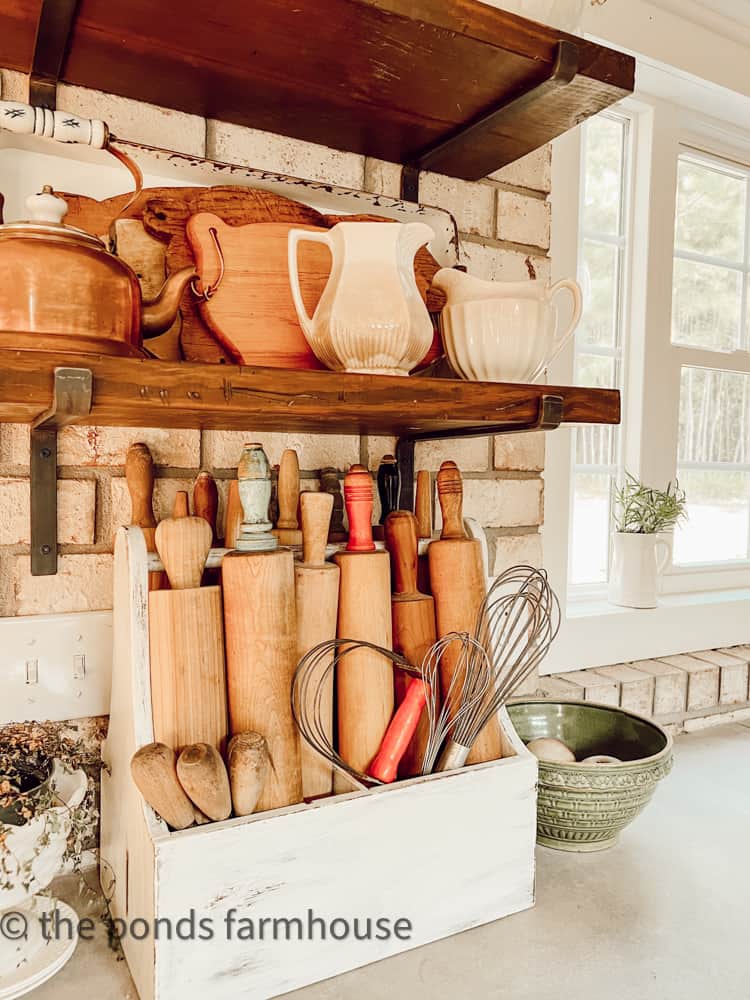 Collections of vintage rolling pins and pig cutting boards fill open shelving in modern farmhouse kitchen.