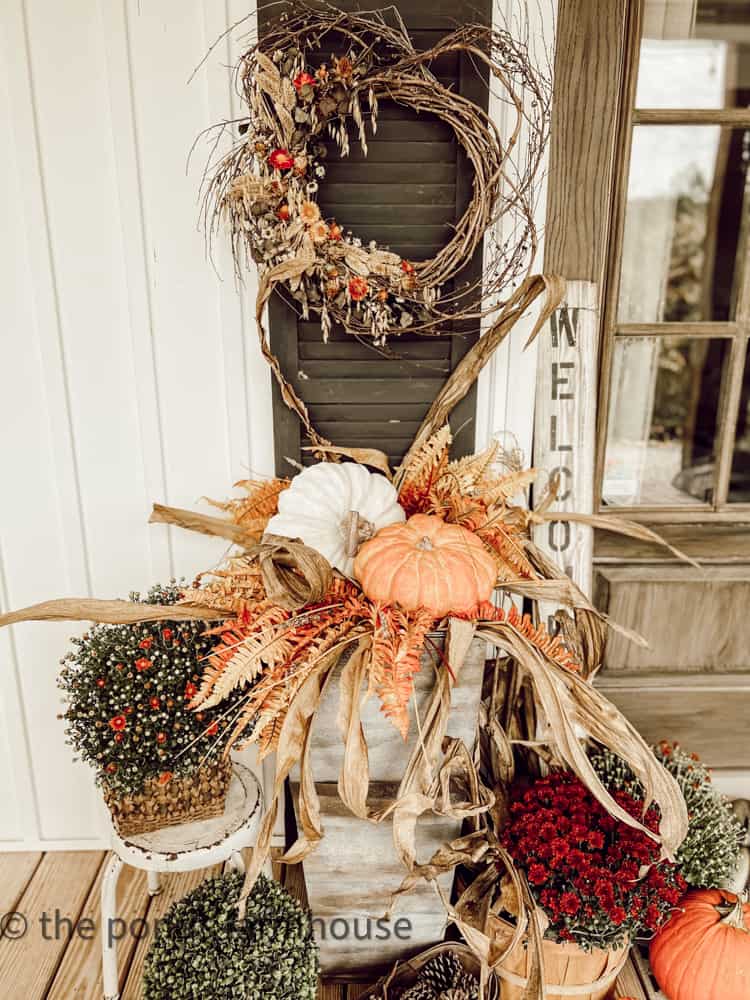 DIY Planters with pumpkin, corn stalks, and mums. 