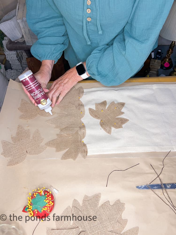 Use Fabric Fusion to attach burlap leaves to the fabric table runner. Farmhouse-style tableware