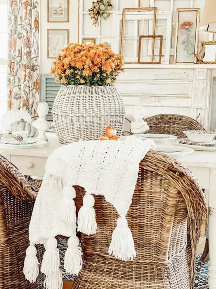 Neutral Thanksgiving Tablescape with orange mum in white wicker basket.  