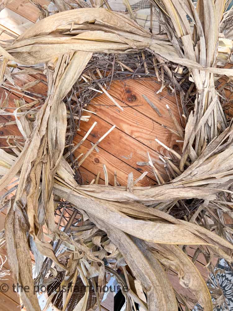 Add bundles of corn husks to wreath