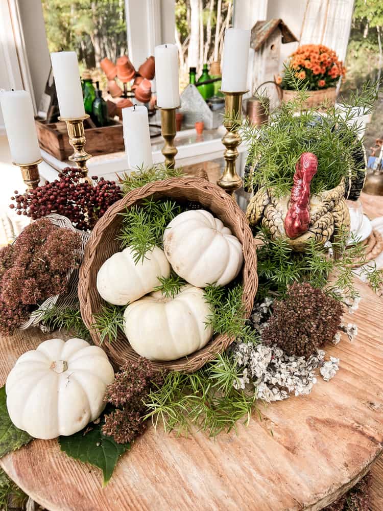 Table Centerpiece for a casual Thanksgiving Dinner Party idea with pumpkins, dried flowers and a vintage turkey.