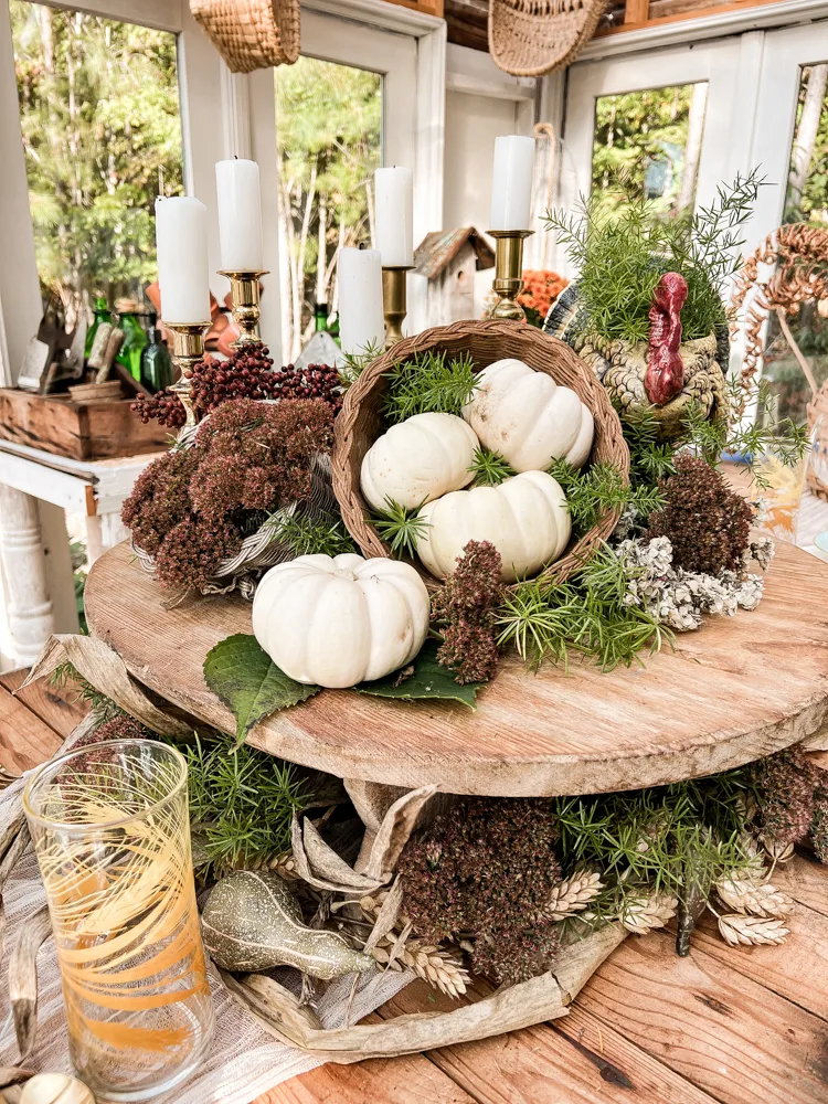 Centerpiece with dried sedum autumn joy blooms, corn stalks, greenery and pumpkins for Friendsgiving Brunch