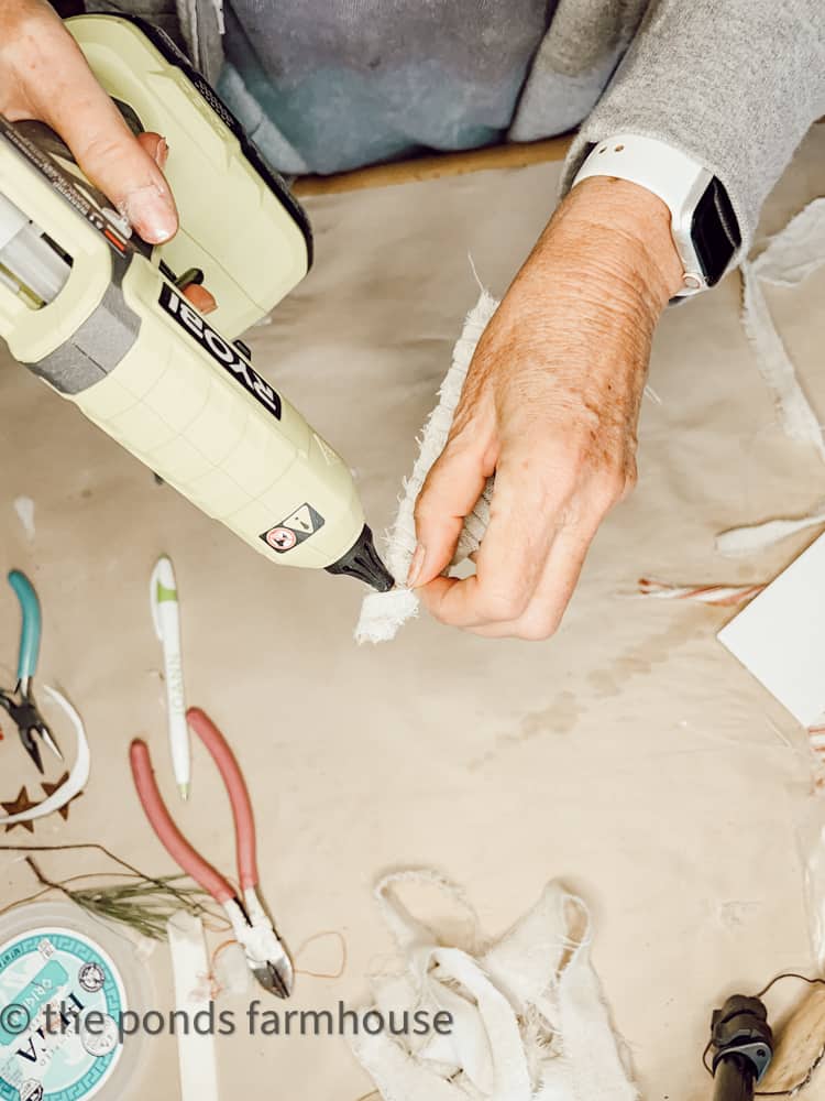 use hot glue to secure the fabric at top of the Christmas Tree made for a package topper