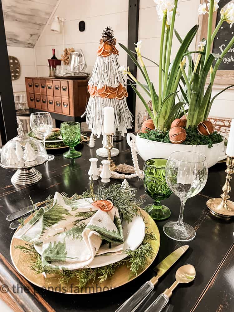 Dining table with small Christmas tree made with oranges. Christmas tablescape.