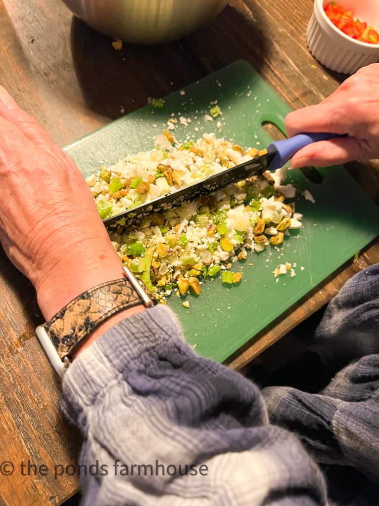 Chop Green onions, feta cheese, pistachio nuts on chopping board for Pistachio Recipe 