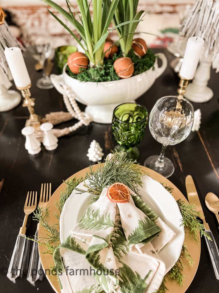Neutral Tablescape for Christmas with Dried Oranges and Natural Greenery.