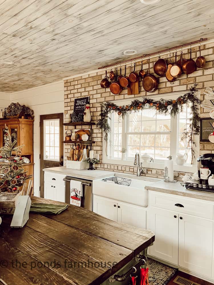 Fresh Cedar and Dried Orange Garland with Jingle Bells of the farmhouse kitchen sink for Christmas.