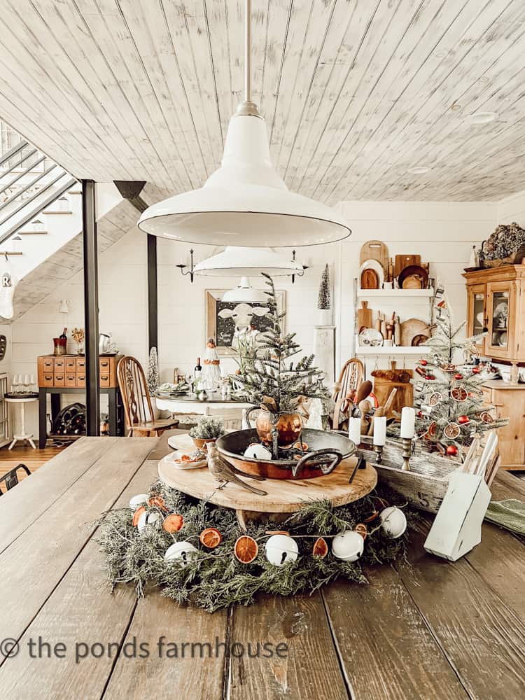 DIY Kitchen Island Decorated for Christmas with French Cheese Board, real cedar, dried oranges and repurposed white bells.  