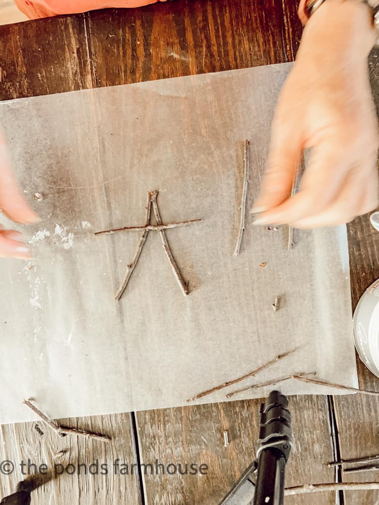 use hot glue to attach eco-friendly twigs to make a star Christmas tree ornaments