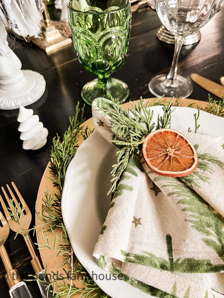 Christmas Tree Napkins with cedar napkin ring and dried orange for Christmas Breakfast Table Setting.