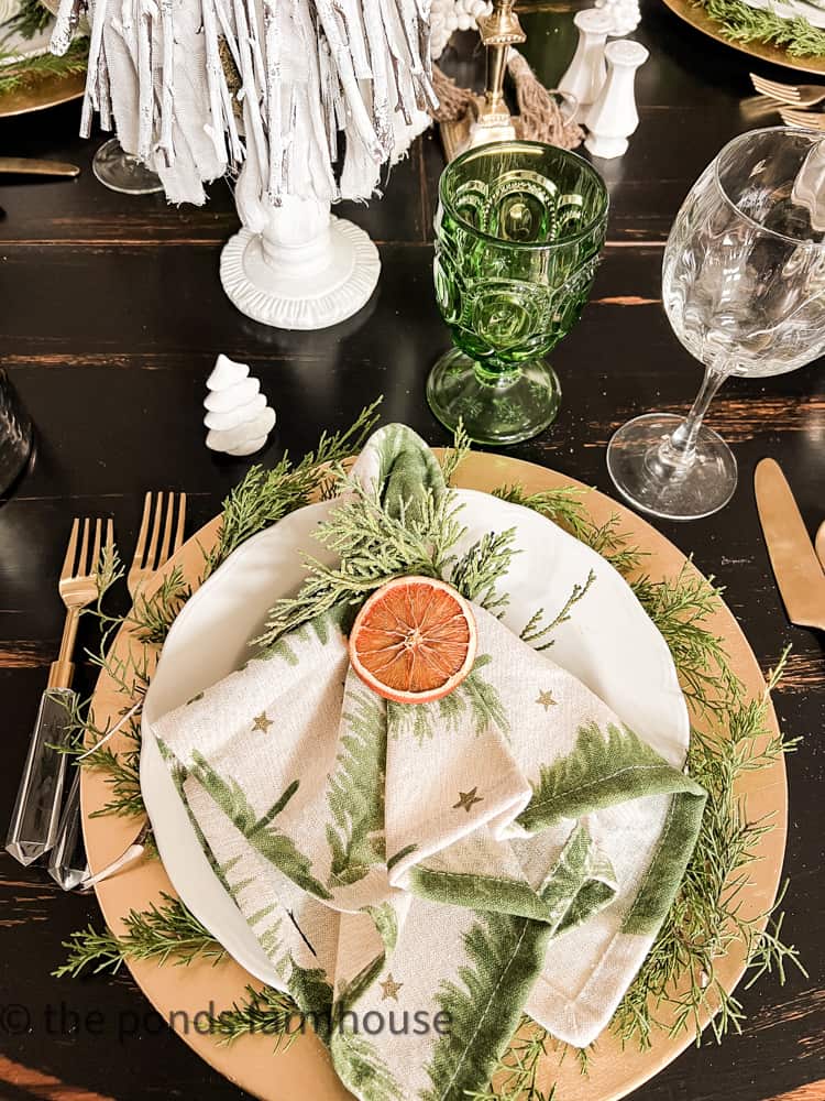 Christmas Tree Napkins with cedar napkin ring and dried orange for Christmas Breakfast Table Setting.