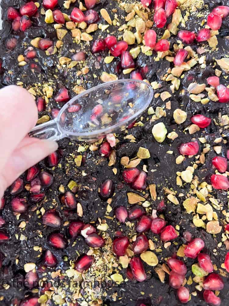 Press pistachio and pomegranates into dark chocolate bark 