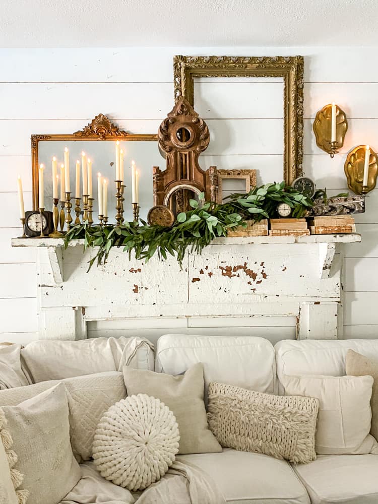 Layer a mantel with vintage and thrift store finds along with fresh greenery for Christmas Decorating.