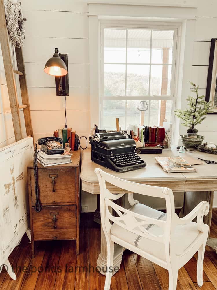 Office Desk with Vintage typewriter, rotary dial phone and wooden file cabinet.  Decorated for Christmas
