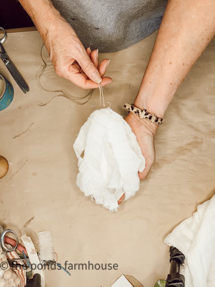 make a tassel with white gauze fabric strips. 