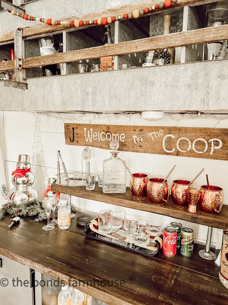 Vintage nest box serves as beverage storage for bar with DIY welcome to the coop sign.