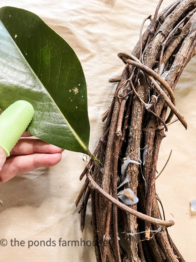 Add leaves to grapevine wreath with hot glue