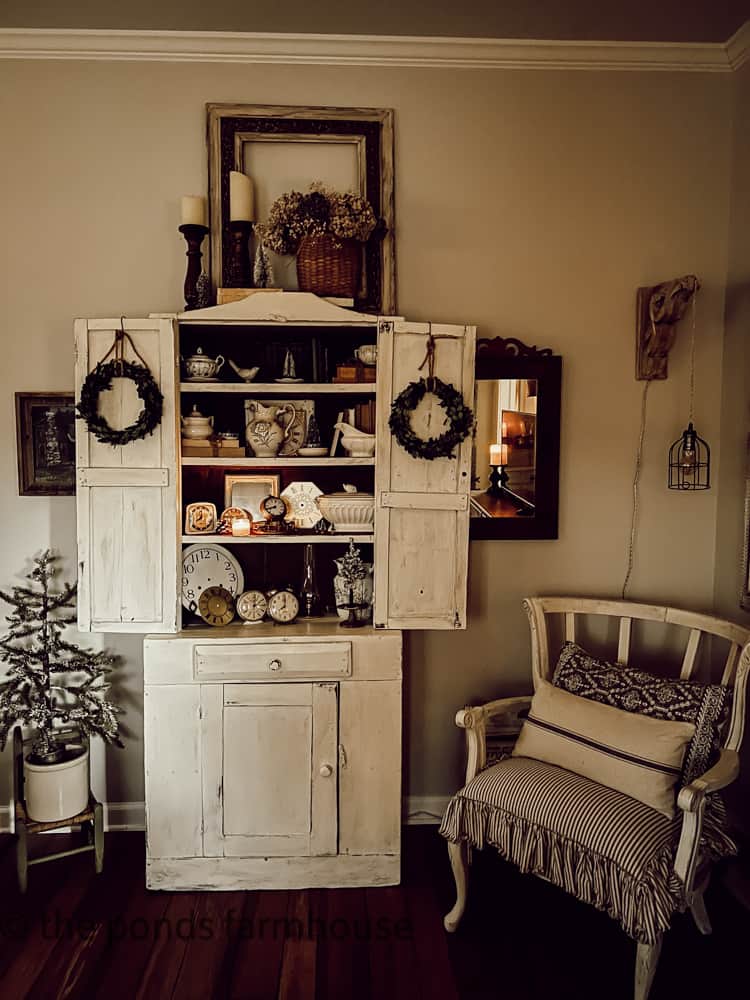 Antique Cabinet filled with vintage and Thrift Store finds for Christmas. Deconstructed Chair.