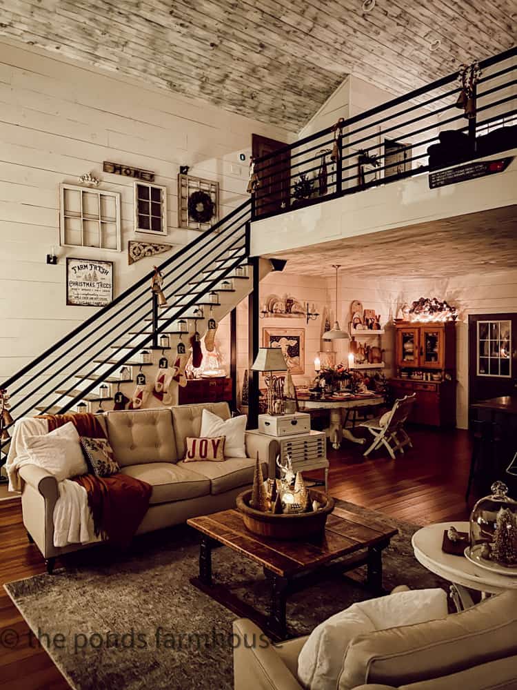 Industrial staircase and dining room view of modern farmhouse decorated for Christmas evening tour.