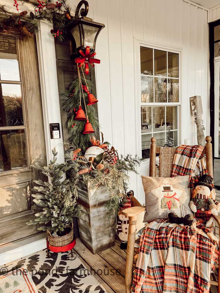 DIY Planted are filled with fresh greenery, bells and pinecones.  Shutters hold greenery swag with bells