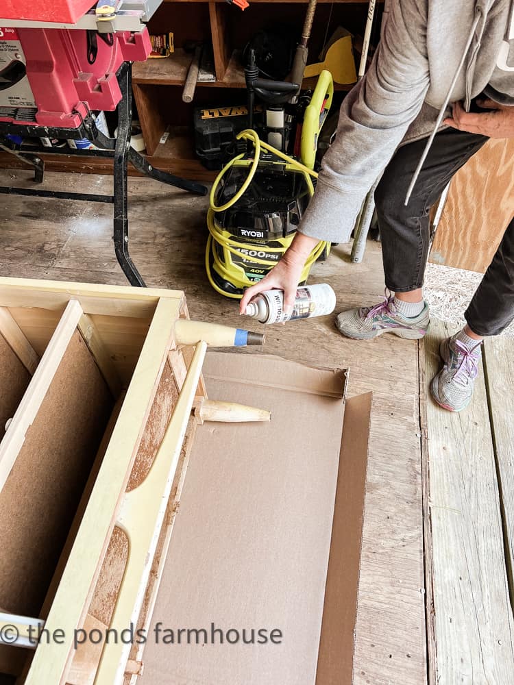 Refinish the metal pieces on the mid-century dresser with antique brass spray paint.