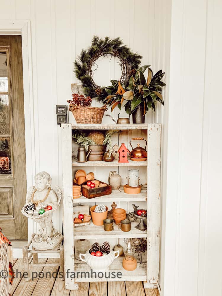 Vintage primitive cabinets hold vintage shiny brites, thrifted clay pots and vintage copper from thrift stores.